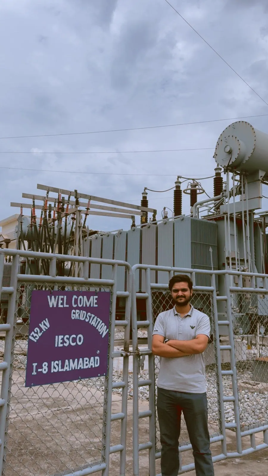 Muhammad Sharjeel at a grid-station site, with electrical yard equipment visible behind him.
