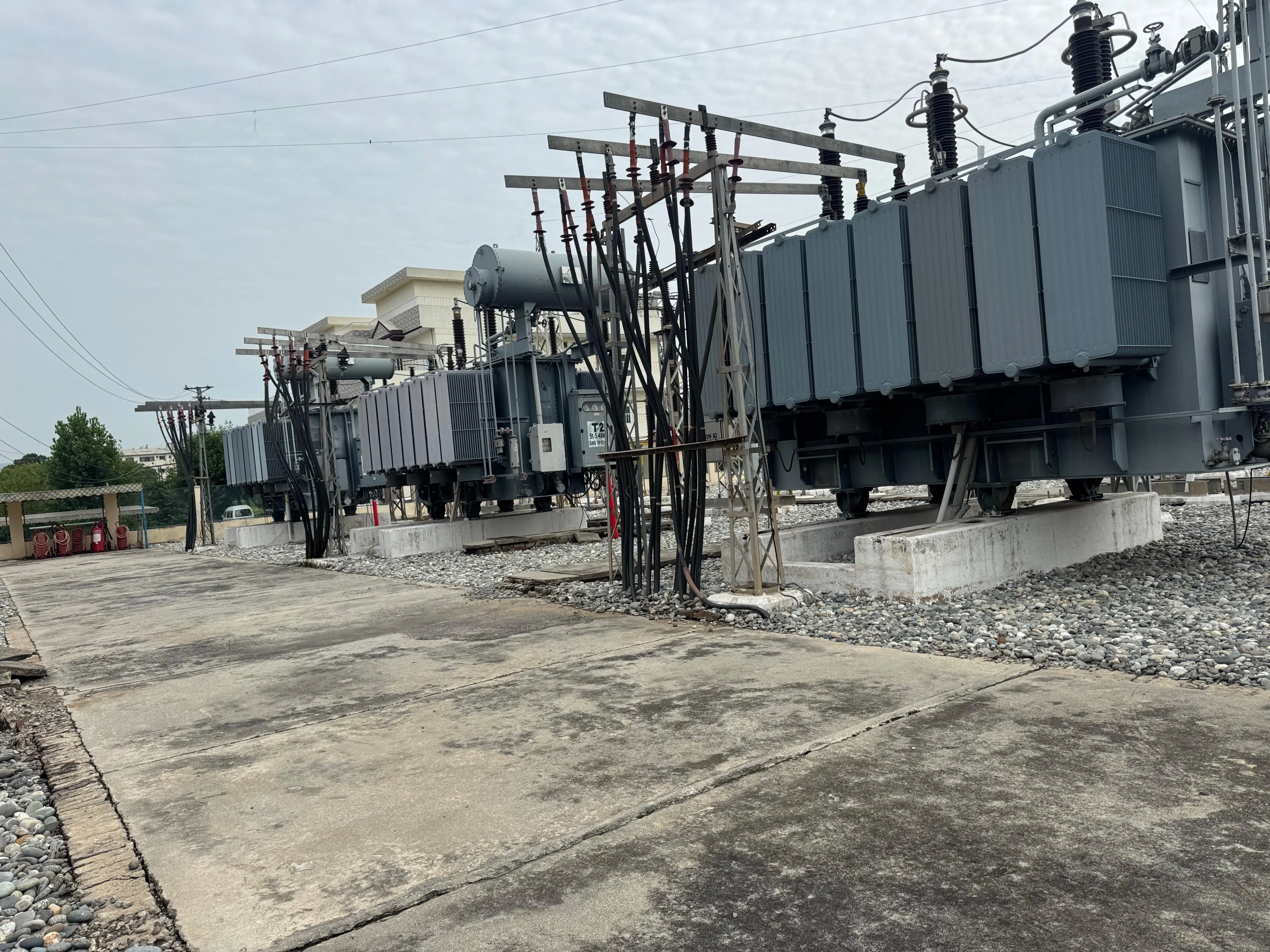 Outdoor substation yard containing power transformers, bushings and electrical connections.