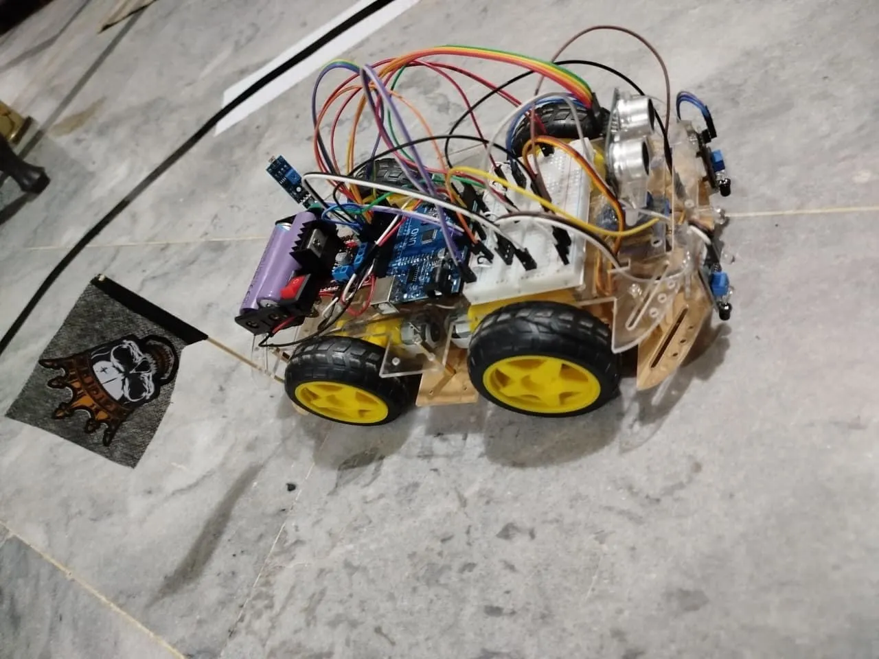 Top view of the robot showing its Arduino UNO, wiring, battery holder and ultrasonic sensor.