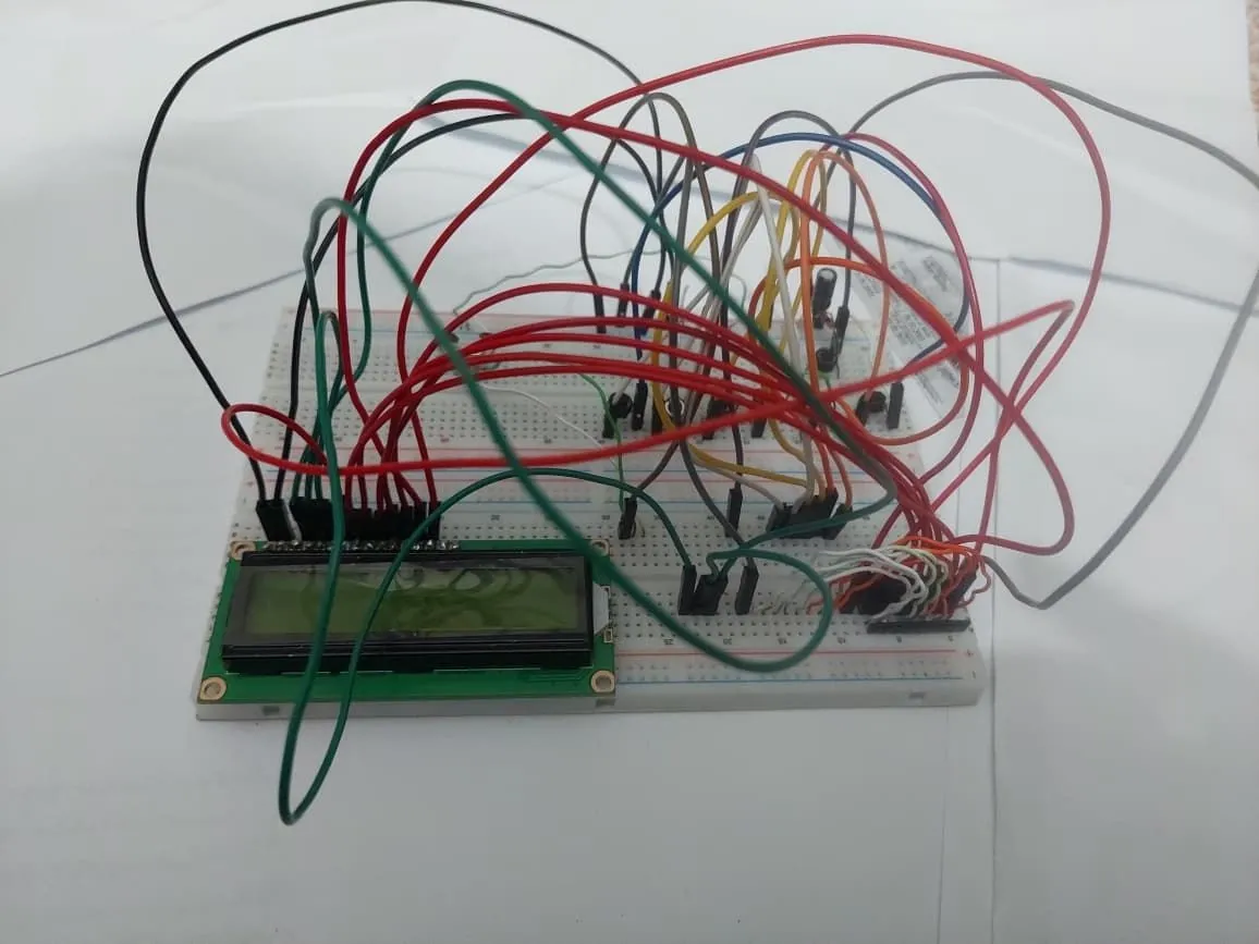 Breadboard voting-machine prototype with a 16 by 2 LCD, push buttons and jumper wiring.